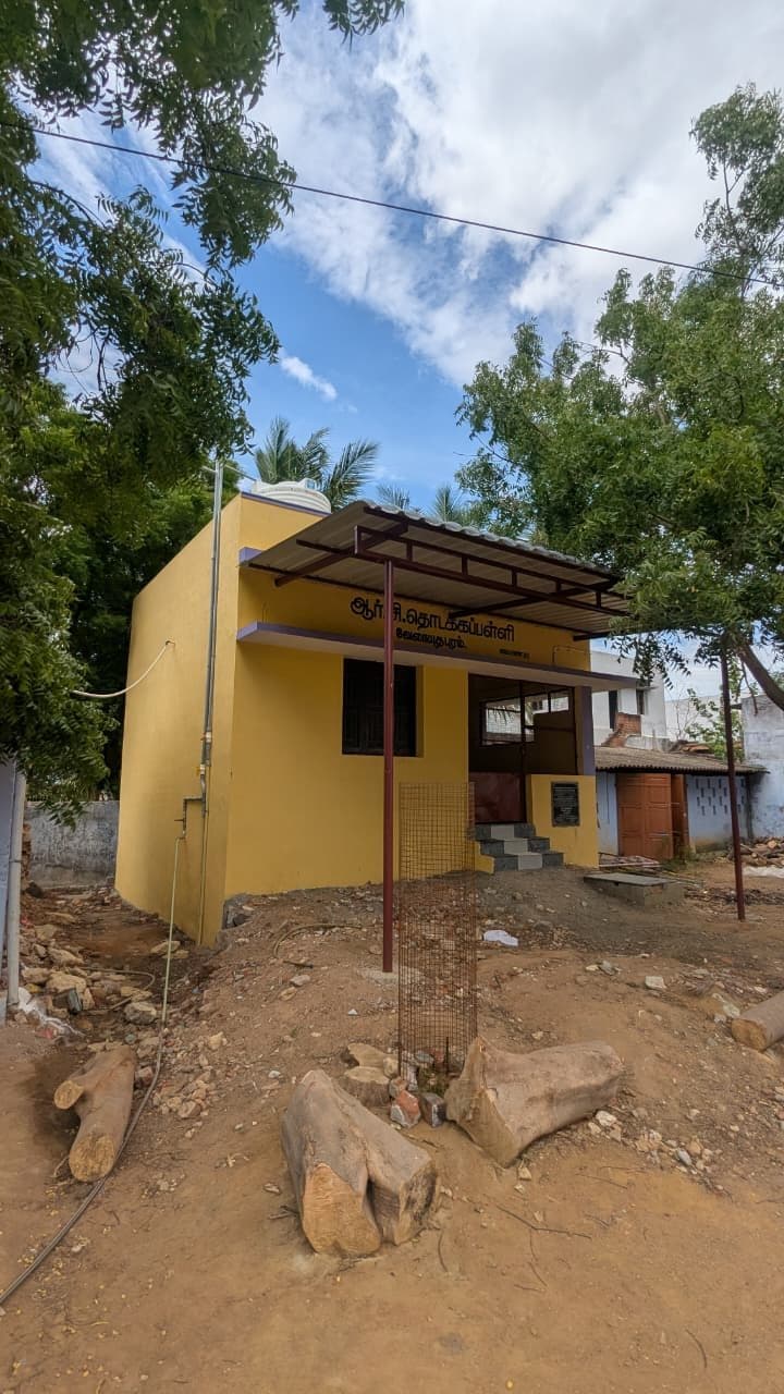 The ancillary block in its site context, with the roof sheeting, rainwater downpipe and surrounding ground still being cleared.