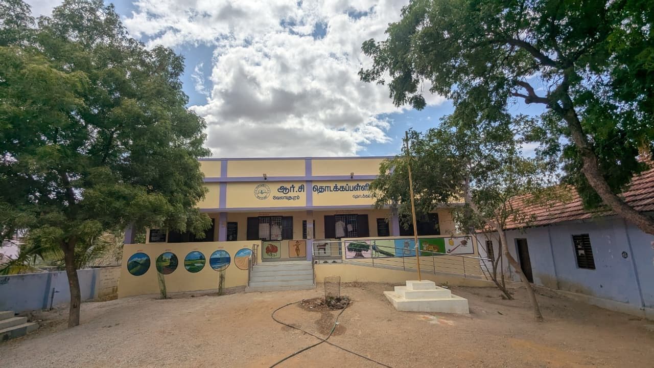 Wide view of the completed school block framed by mature trees.